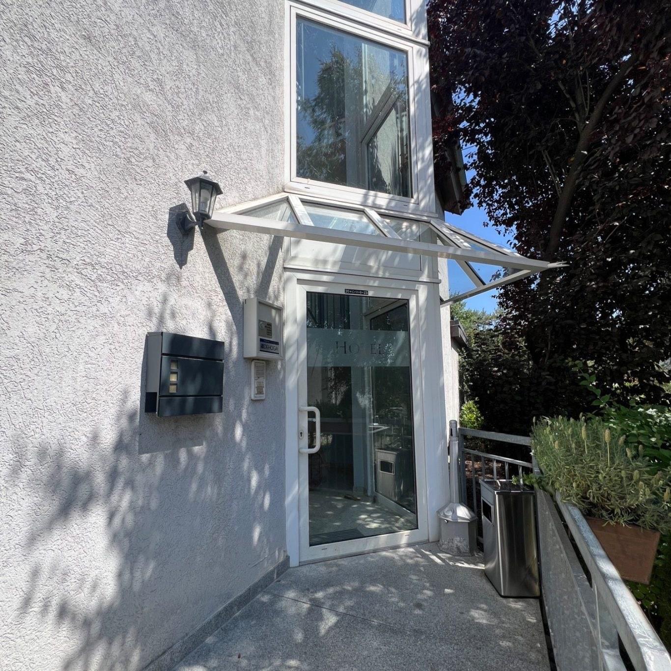 Eingang des Hotel am Neckar mit weißem Glasvordach und heller Fassade